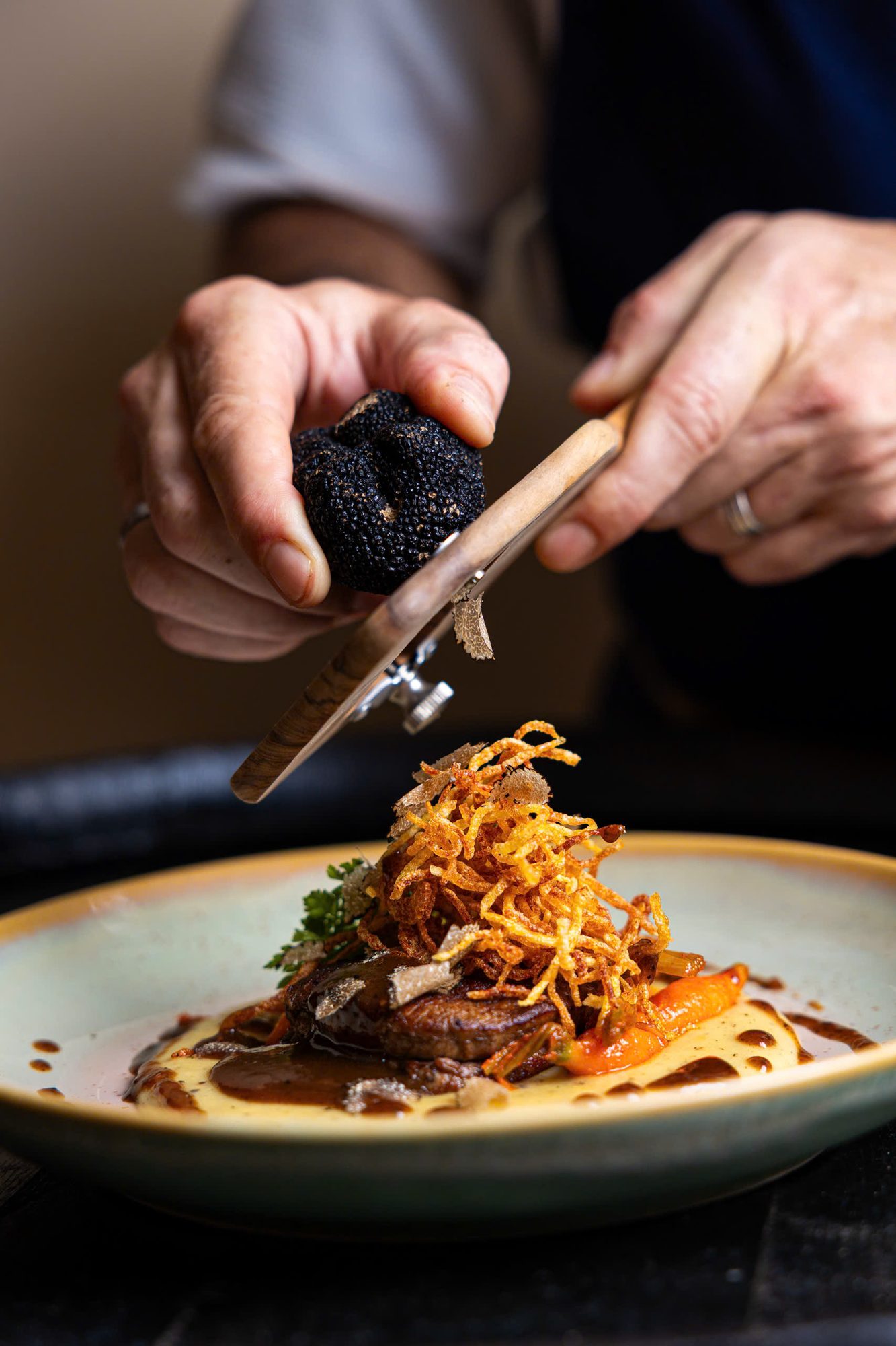 Chef shaving truffle over dish